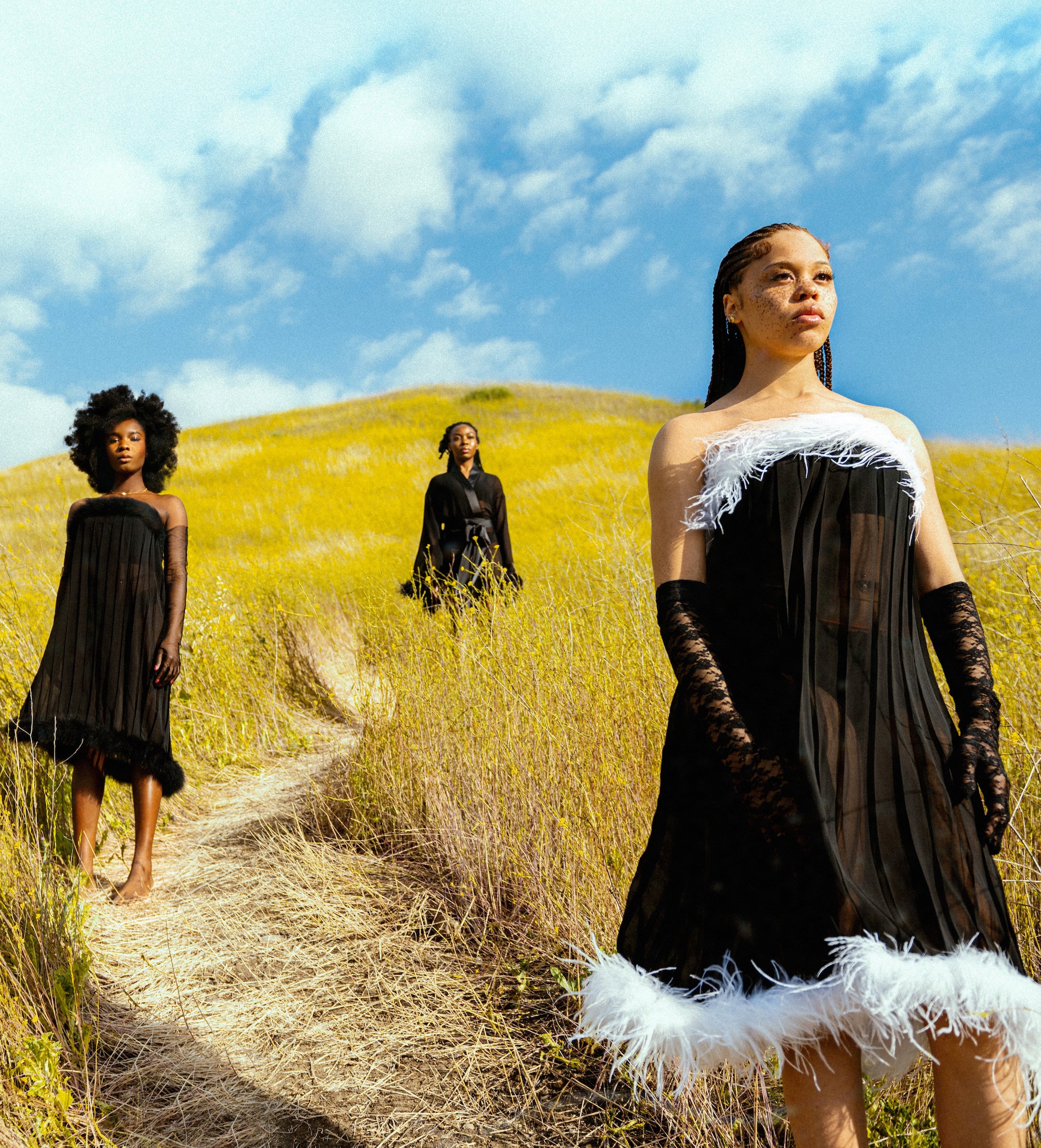 Three beautiful black female models posing on a grassy hill wearing loungewear by SHOLAYIDÉ