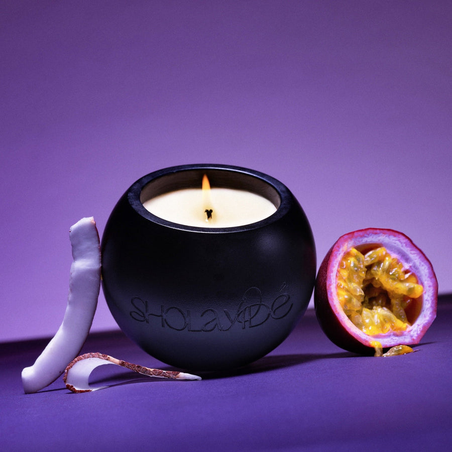 EXALTED eco-luxe vegan scented candle by SHOLAYIDÉ paired with fresh coconut slices and passionfruit.