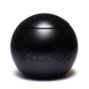 FAVORED by SHOLAYIDÉ, an eco-luxe vegan candle in a black sphere cement candle jar on a white background.