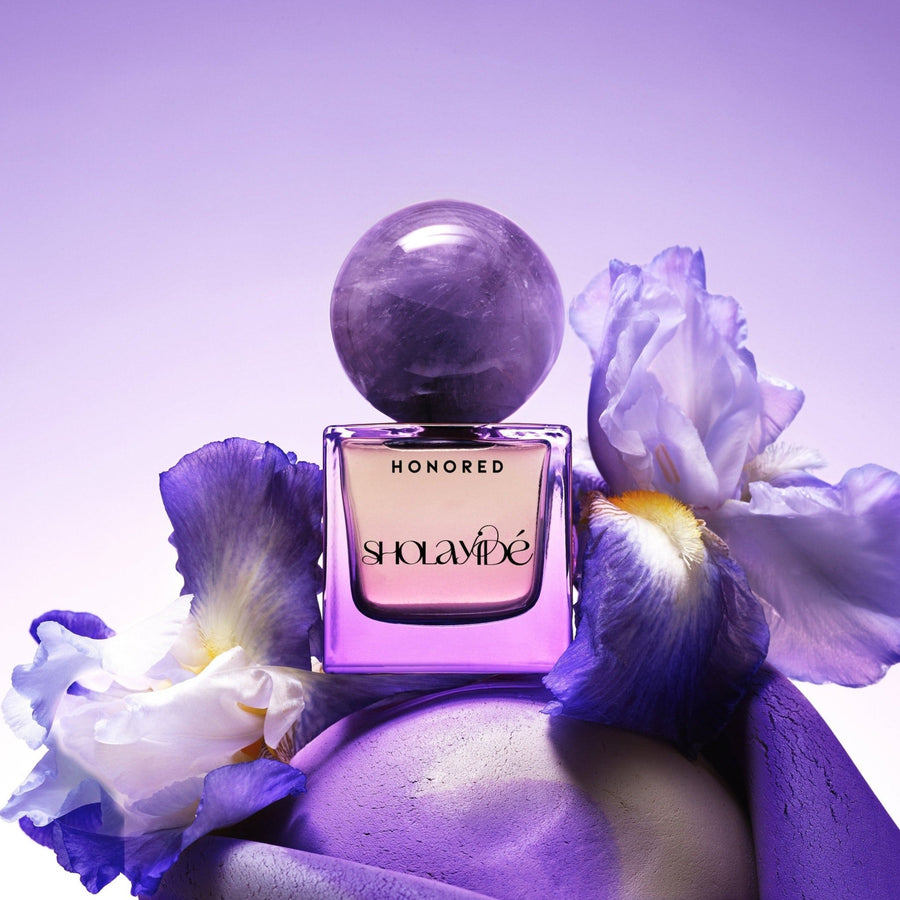 HONORED by SHOLAYIDÉ, eco-luxe eau de parfum purple ombre bottle with amethyst crystal cap on white background.