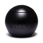 PRAISED by SHOLAYIDÉ, an eco-luxe vegan candle in a black sphere cement candle jar on a white background.