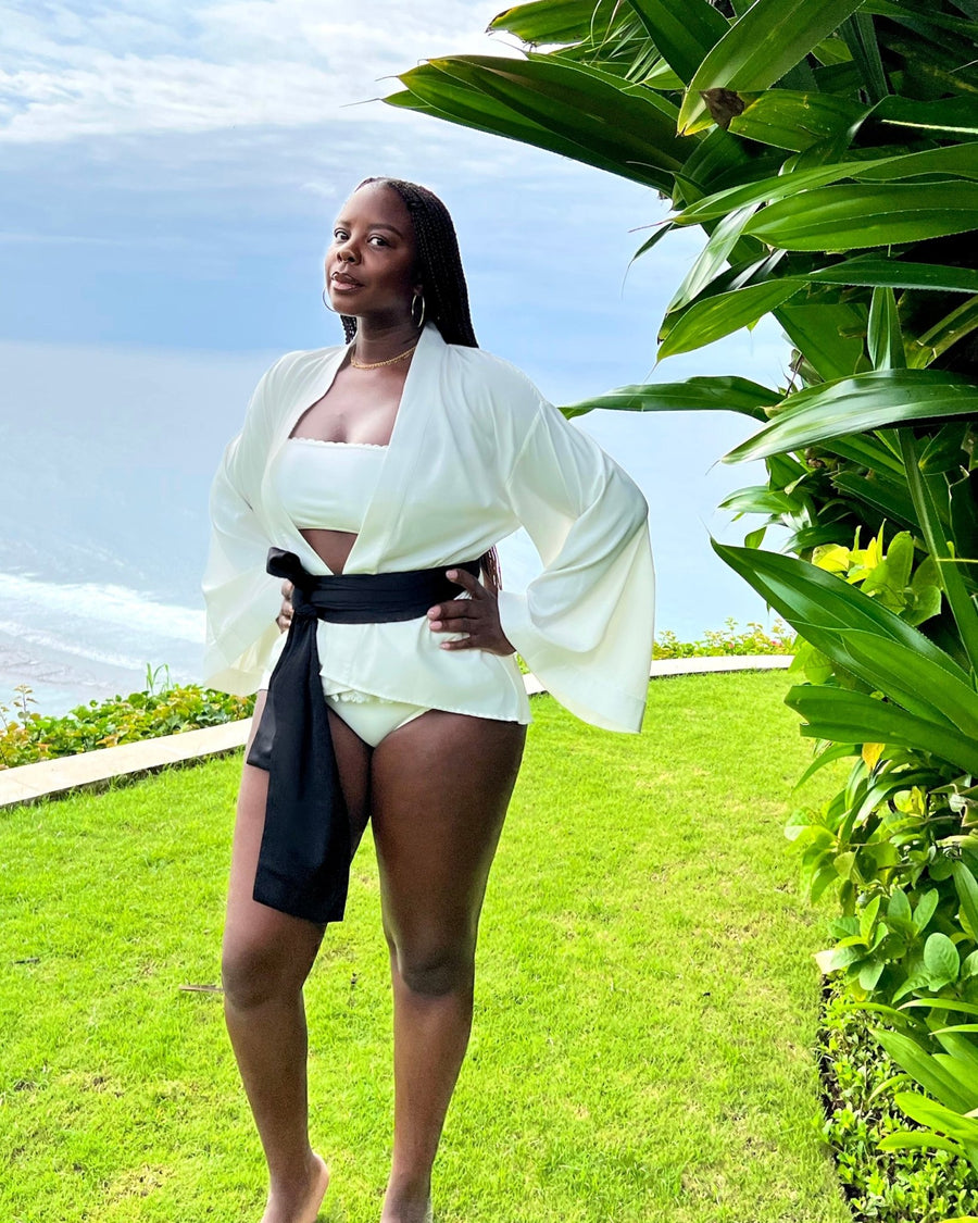 Founder, Sholayide Otugalu posing in a garden in Bali, Thailand wearing the ESTHER tunic by SHOLAYIDÉ.