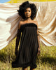 Black female model posing on a grassy hill wearing the EVE fur trim dress by SHOLAYIDÉ