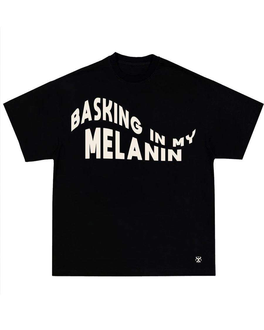 MELANIN black t-shirt with Basking in My Melanin embroidery detail by SHOLAYIDÉ laying on white background.