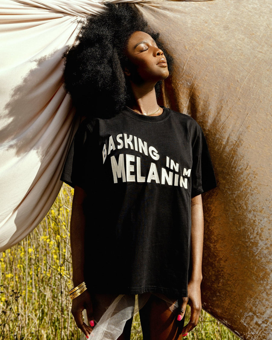 Our MELANIN t-shirt celebrates the poised & magical Black woman with an embroidered, wavy design of 